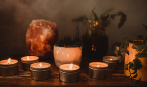 Skinny Dip Candles lit with a smoky backdrop of plants and salt lamp.